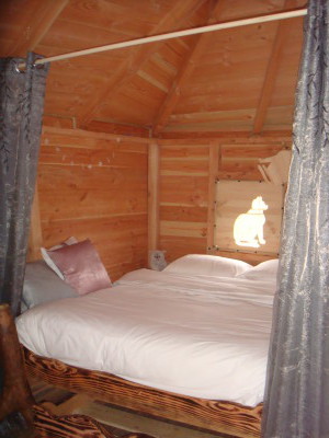 Le lit des sorcières est blottit dans un renfoncement de la cabane. Un lit tiroir est dissimulé en dessous de ce lit double.
